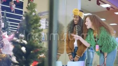 两个朋友在商店橱窗里检查圣诞装饰品。